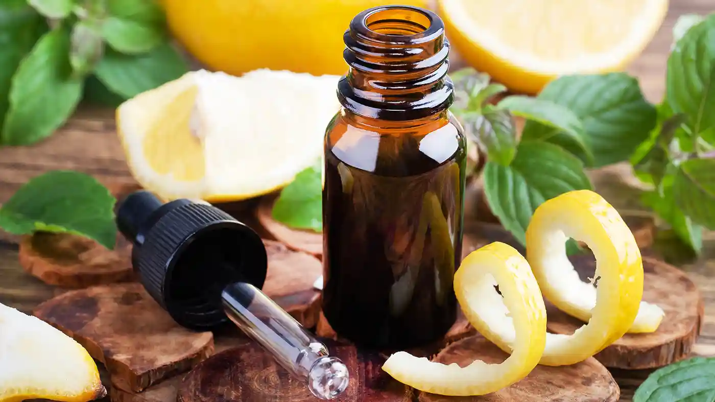 Lemon peels in front of amber glass bottle