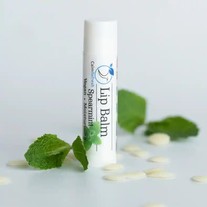 Spearmint Lip Balm surrounded by Spearmint leaves